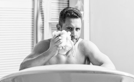 Treating yourself with a hot or warm bath can feel like the height of luxury. Man handsome muscular...