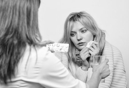 By prescription only. Medical doctor examining patient. Doctor visiting unhealthy woman at home. Primary care doctor making diagnosis to sick woman. Patient care and healthcareの写真素材