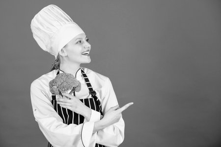 Healthy food. Dieting concept. Eat healthy. Girl hold vegetable. Organic nutrition. Healthy vegetarian recipes. Woman chef hold broccoli pointing at copy space. Amazing broccoli facts you should knowの写真素材