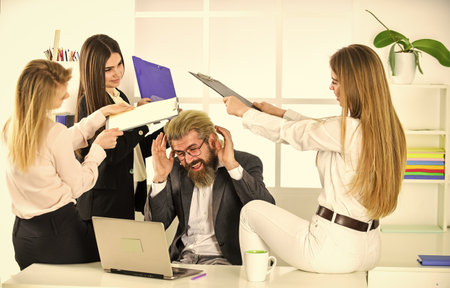 Welcome to play. business colleagues in modern office. stressed boss is surrounded by assistants. women and man discuss work. colleagues brainstorming in talk chatting. explain ideas at workplaceの写真素材