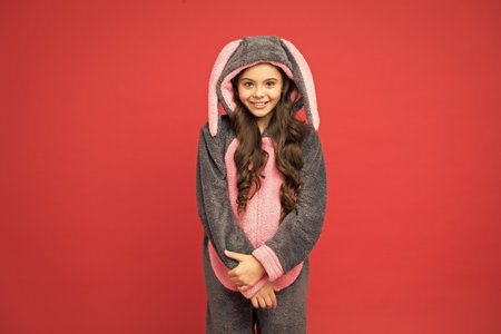 Cute everyday. Cute child red background. Cute girl wear bunny pajamas. Small kid with cute look. Easter. Spring. Be your owm kind of beautifulの写真素材