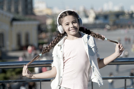 Audio tour headphones gadget. City guide and audio tour. Girl little tourist kid explore city using...