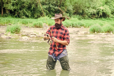 best day ever. bearded fisher in water. fisherman show fishing technique use rod. mature man fly fishing. man catching fish. hobby and sport activity. summer weekend. Happy fly fishingの写真素材