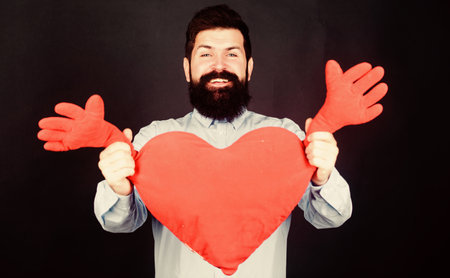 Man bearded hipster hug heart. Celebrate valentines day. Guy with beard and mustache in love romantic mood. Feeling love. Dating and relations concept. Happy in love. Physical touch. Free hugsの写真素材