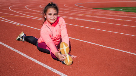 girl kid training sport outside on stadium arena sit in split, flexibilityの写真素材