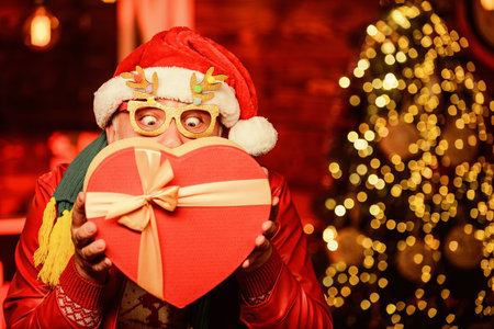 Kindness and generosity. Giving gift. Delivery service. Gift shop. Man senior Santa claus hold gift box. Winter ideas. Celebrate new year. December sale. Christmas gift. Spread love. Surprise conceptの写真素材