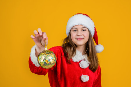 happy christmas child girl wear red santa claus hat and costume hold tree decoration, preparationの写真素材