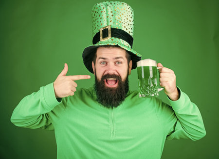 Drinking beer part celebration. Fest and holiday menu. Dyed green traditional beer. Lets start patricks party. Alcohol beverage. Irish tradition. Man brutal bearded hipster drink beer. Irish pubの写真素材