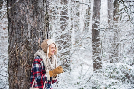 Winter hike. Warm yourself up. Woman winter drink. Girl enjoy mulled wine. Woman in hat drinking tea...