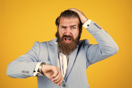late man look at time on clock. bearded mature hipster wear jacket. confident businessman has trendy hairstyle. male with beard having formal look. male beauty and fashionの写真素材