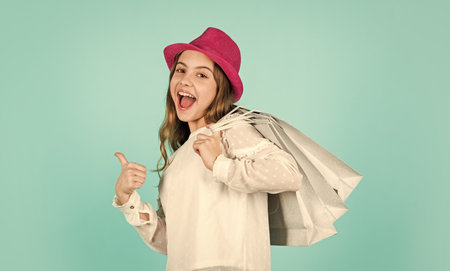 Spring shopping. Individual style. Girl wear hat blue background. Accessories shop. Fancy girl shopping. Shopping tour sales season. Summer accessory collection. Fashion accessory. Child wear hatの写真素材