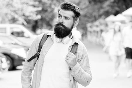 Discover local showplace. Backpack for urban traveling. Hipster backpack urban street background. Tourism and backpacking. Vacation concept. Modern rest. Bearded man travel. Guy exploring cityの写真素材