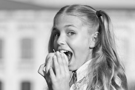 Eat for health. Happy child bite apple outdoors. Natural dieting. Dental health. Oral hygiene....