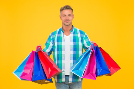 successful mature shopper man carry shopping bags, sale and discount