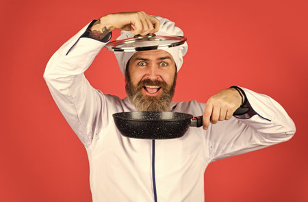 baker with saucepan pot. catering. Chef man holds kitchenware. happy cook man hold frying pan. Chef in uniform cooking soup. restaurant kitchen. cooking lunch in kitchen. my professionの写真素材