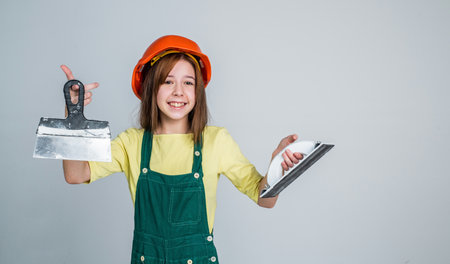 girl kid in hard hat on construction site use spatula, equipmentの写真素材
