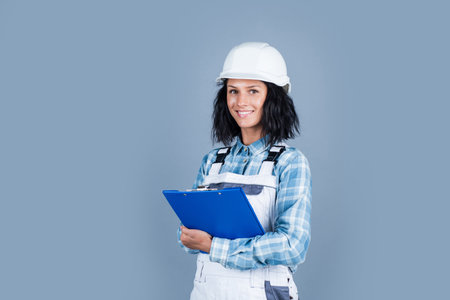 Foreman inspector. girl in checkered shirt and protective hard hat. building and construction site....