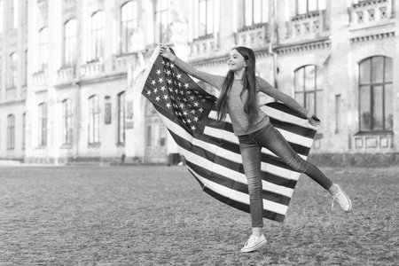 Little girl with american flag outdoors architecture background, museum national history conceptの写真素材