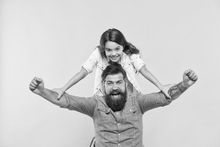 Love in our family grows deep. Happy family celebrate yellow background. Father and little daughter winth winning gesture. Bearded man and small child. Family values. Always there to always careの写真素材