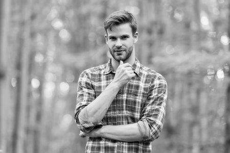 Bearded man in plaid shirt with unshaven facial hair travel in summer nature, beard