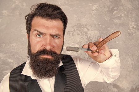 Bearded and stylish. Retro and classical fashion. Hair and beard care. Confident and handsome brutal man. male morning grooming. personal facial care. Shaving man has razor. Hair salon for menの写真素材