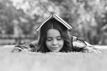 Calming book. Small child sleep on green grass. Bibliotherapy. Mindfulness and relaxation. Napping...