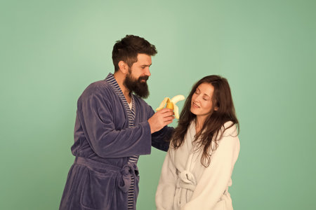 Its not going to suck itself. Bearded man feed sexy woman with banana. Love games. Couple in love blue background. Love and desire. Erotic love. Blowjob and oral sex. Healthy lifestyle and dietの写真素材