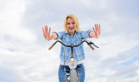 Check it out. Bicycle tricks. Woman likes to ride bike. Can everyday bicycling make you happier. Bicycling her hobby and best way to relax and reduce stress. Girl can ride her bike with no handlebarsの写真素材