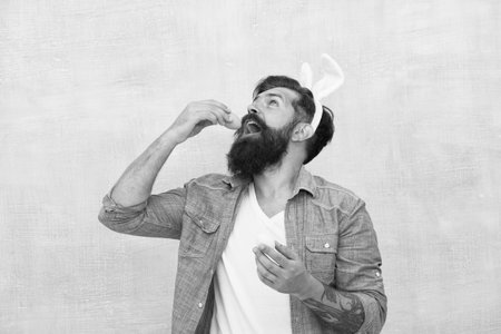 Culture customs and traditions. Easter bunny colored eggs. Celebration of spring holiday. Bearded man bunny ears and Easter eggs. Everything you need for Easter is here. Hipster long ears holding eggの写真素材
