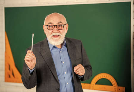 techniques for studying maths. protractor ruler. learn geometry easily. become good at math. stem in classroom. senior man teacher use tool at blackboard. bearded tutor in glasses. back to schoolの写真素材