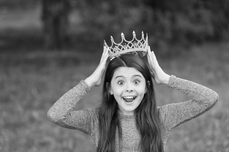 Cute girl golden crown outdoors green nature background, such an honor conceptの写真素材