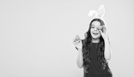 child with painted eggs. follow traditions. Funny preparing for Easter. Happy easter holiday. Collecting Easter eggs. Funny hare kid on egg hunt. small girl feel happiness. copy spaceの写真素材