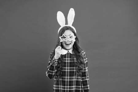 girl in Easter bunny during egg hunt. party and child concept. spring family holiday. little cute bunny. portrait of child with party glasses. having fun. funny kid wear bunny earsの写真素材