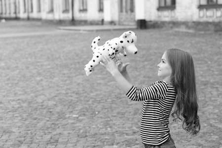 Life full of fun. Happy kid play with toy dog outdoors. Enjoying playtime. Play and fun. Childhood fun. Leisure and free time. Active games. Summer vacation. International childrens day, copy spaceの写真素材
