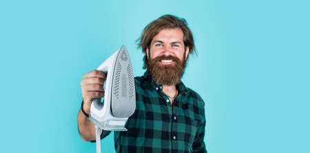 brutal bearded male man hold steaming iron, appliancesの写真素材