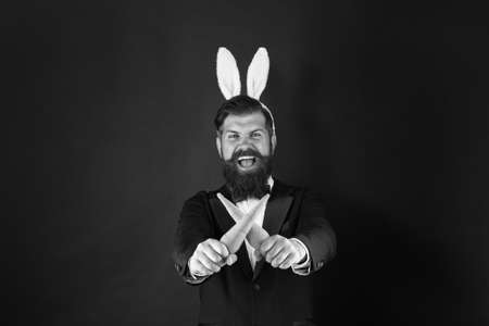 Carrot is always good idea. Rabbit costume party. Bunny or hare. Easter symbol. Holiday celebration. Easter rabbit black background. Bearded man hold carrots. Happy businessman wear rabbit earsの写真素材