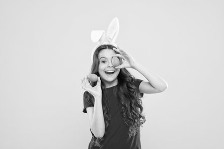 Funny games. Indoor and outdoor holiday activities. Fun and educational Easter activity for kids. Little girl easter eggs. Cute cheerful bunny schoolgirl celebrate Easter day. Preparing decorationsの写真素材
