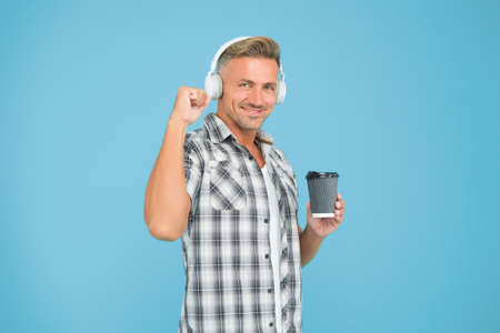 Good mood. Stress resistance concept. Guy listening music headphones and drinking coffee. Regular...