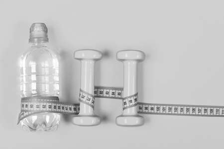 Centimeter wrapped around bottle and dumbbell, top view.の写真素材