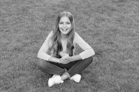 Happy smiling little girl relaxing green grass, excited child concept