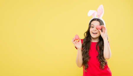 child with painted eggs. follow traditions. Funny preparing for Easter. Happy easter holiday. Collecting Easter eggs. Funny hare kid on egg hunt. small girl feel happiness. copy spaceの写真素材
