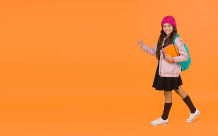 School is back. Happy small child back to school. Little girl go to school orange background. Back to class. September 1. Welcome back in autumn, copy spaceの写真素材