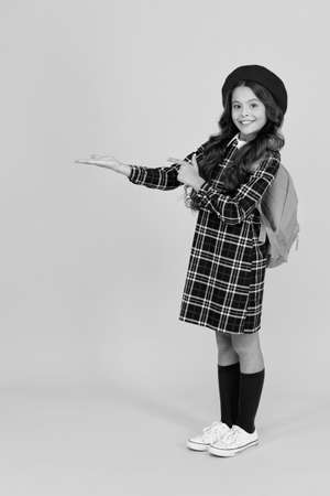 cute child presenting product in uniform, school marketの写真素材