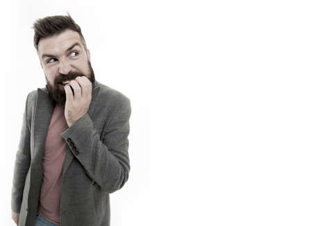 Man bearded hipster doubtful face bites finger while thinking. Nervous make decision. Hipster brutal nervous thoughtful face expression. Nervous decision concept. Nervous about solving problemの写真素材