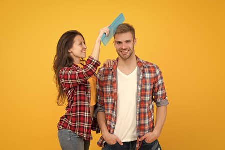 Hairdresser services. Creative mood. Change hairdo. Hair care at home. Helping with hairstyle. Couple having fun with big comb. Combing and brushing hair. Man and woman taking care hair themselvesの写真素材