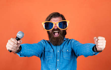 good day. male sing music in microphone. funny bearded man with mic. brutal caucasian hipster in...