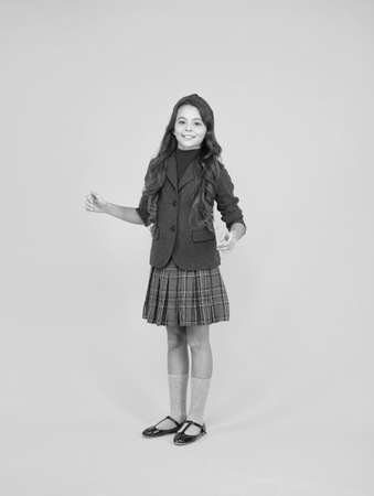 Happy child wear uniform yellow background. School dress. Formal style. Fashion school uniform. Clothing standards. Elementary education. September 1の写真素材
