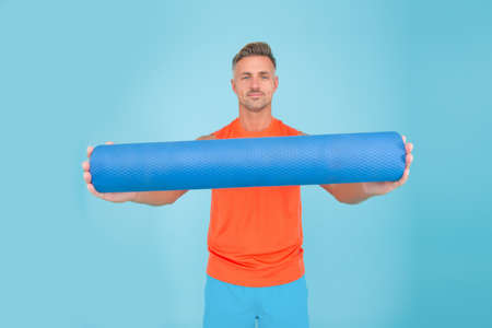Personal training. Meditations designed to help you find your joy. Man practicing yoga at home. Handsome sportsman with yoga mat. Workouts with modifications for different levels. Yoga is my hobbyの写真素材