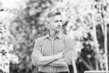 Businessman in casual clothes. Handsome man nature background copy space. Attractive adult man. Rest and relax. Sunny spring day. Confident man. Good looking guy outdoor. Male beauty and fashionの写真素材