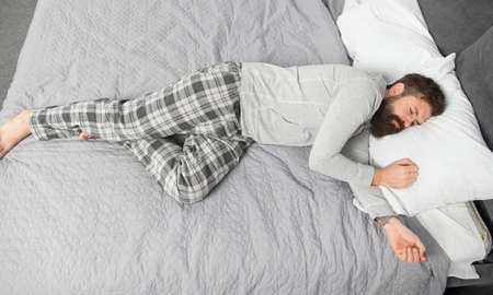 brutal sleepy man in bedroom. mature male with beard in pajama on bed. asleep and awake. energy and tiredness. bearded man hipster sleep in morning. Deep sleep. When the party is overの写真素材